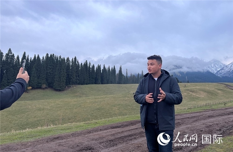 在庫爾德寧，吾買爾江被雪山美景震撼，即興錄制了短視頻作品。人民網(wǎng)記者曾書柔攝