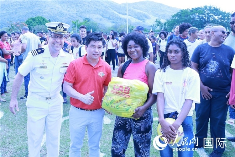 巴西中國浙江商會會長鄭俠茂向巴西貧困社區(qū)兒童及家庭捐贈基礎(chǔ)食品籃子和足球。人民網(wǎng)記者陳海琪 攝