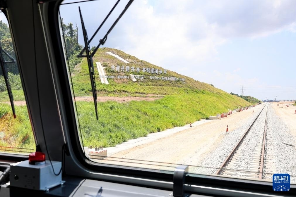5月6日，在馬來西亞彭亨州馬東鐵項(xiàng)目沿途的山坡上，兩行中文和馬來文大字“共商共建共享，共創(chuàng)美好未來”映入眼簾。新華社記者 程一恒 攝