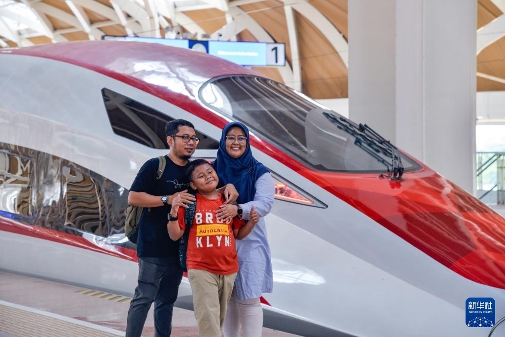 4月17日，在印度尼西亞雅加達(dá)哈利姆站站臺(tái)，乘客和雅萬高鐵高速動(dòng)車組列車合影。新華社記者 徐欽 攝