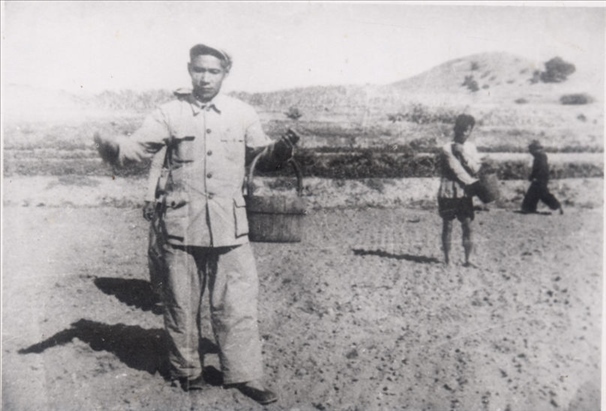 谷文昌（左）在田間與農(nóng)民一起勞動(dòng)（資料照片）。