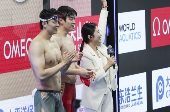  10月18日，汪順（左）和潘展樂在男子100米混合泳決賽后。新華社記者 方喆 攝