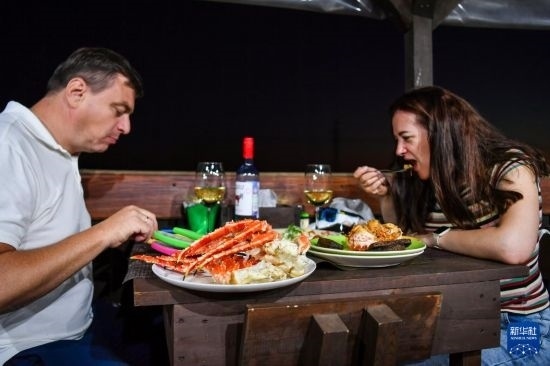 9月2日，食客們在俄羅斯符拉迪沃斯托克的一家餐館品嘗帝王蟹。新華社記者 曹陽 攝