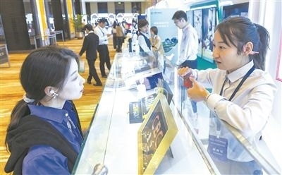 在北京麗澤商務(wù)區(qū)，工作人員（右一）介紹數(shù)字人民幣SIM卡硬錢包。新京報記者 陶冉攝