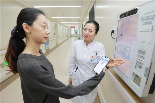 醫(yī)護(hù)人員引導(dǎo)患者在自助機(jī)前辦理自助入院手續(xù)。圖片來源：山東第一醫(yī)科大學(xué)第二附屬醫(yī)院