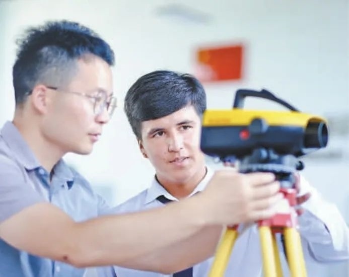 在塔吉克斯坦首都杜尚別的魯班工坊，來(lái)自天津城市建設(shè)管理職業(yè)技術(shù)學(xué)院的老師（左）為當(dāng)?shù)貙W(xué)生提供指導(dǎo)。新華社記者 鄭開(kāi)君 攝