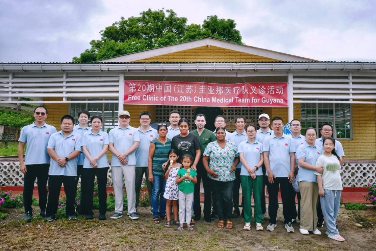第20期中國(guó)（江蘇）援圭亞那醫(yī)療隊(duì)在圭偏遠(yuǎn)的林登高速社區(qū)開(kāi)展義診后，與部分當(dāng)?shù)鼐用窈嫌啊?中國(guó)援圭醫(yī)療隊(duì)供圖
