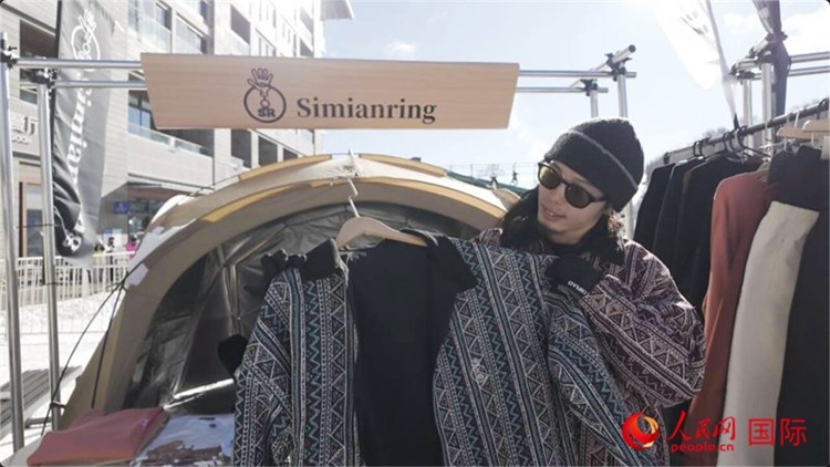 藤田周正在展示自己設(shè)計(jì)的滑雪服。人民網(wǎng)記者 袁蒙攝