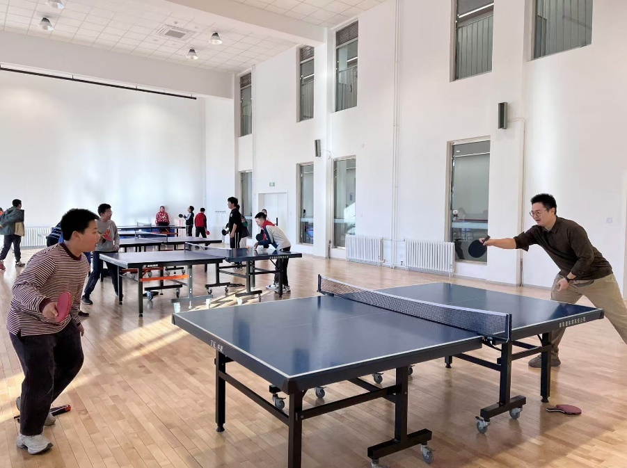 老師和學生在課間打乒乓球。人民網 白炅攝