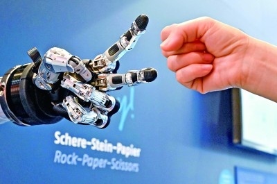 在德國(guó)漢諾威工博會(huì)上，參觀者與一款智能機(jī)器人進(jìn)行“石頭剪子布”游戲。新華社發(fā)