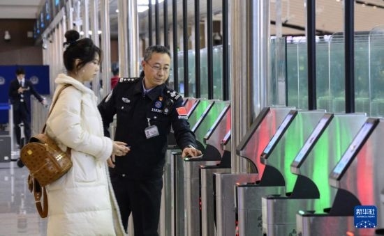 1月2日，大興機場邊檢站警察指導(dǎo)旅客使用自助出境設(shè)備。新華社記者 李欣 攝