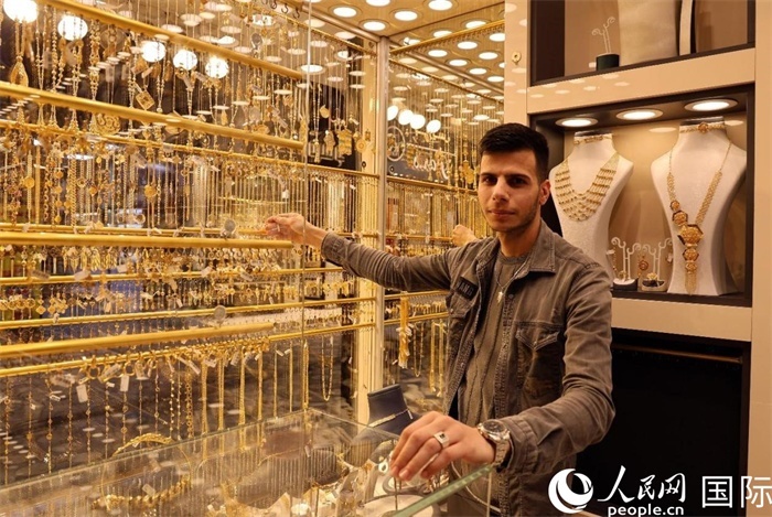 一名銷售員展示黃金飾品。人民網(wǎng) 伊納斯·易卜拉欣攝