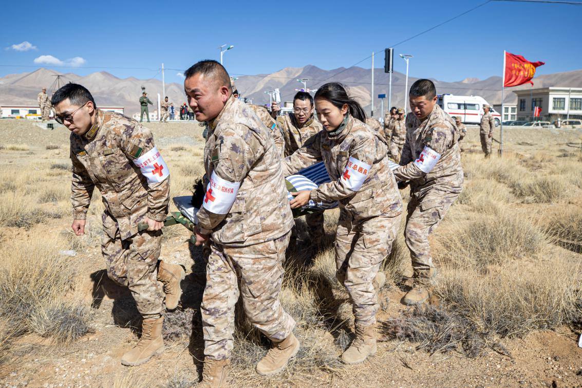 1月9日，日喀則定日縣長(zhǎng)所鄉(xiāng)，西藏軍區(qū)總醫(yī)院醫(yī)療隊(duì)隊(duì)員將受傷村民用擔(dān)架從救護(hù)車(chē)準(zhǔn)備抬上直升機(jī)，轉(zhuǎn)運(yùn)至拉薩的西藏軍區(qū)總醫(yī)院救治。人民日?qǐng)?bào)記者張武軍攝