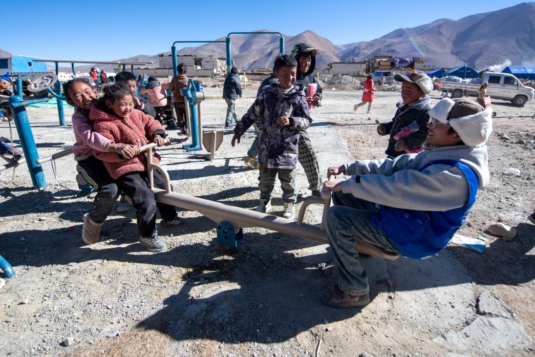 1月11日，在定日縣措果鄉(xiāng)塘仁村安置點(diǎn)，西藏星光社會(huì)工作服務(wù)中心志愿者和孩子們一起玩耍，進(jìn)行災(zāi)后心理疏導(dǎo)。人民網(wǎng)記者 翁奇羽攝