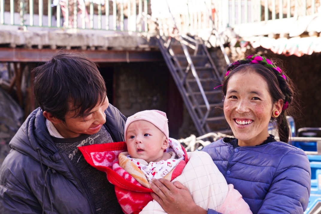 1月11日，在西藏日喀則市人民醫(yī)院，受災(zāi)群眾抱著自己在地震中受傷的孩子康復(fù)出院。人民日?qǐng)?bào)記者徐馭堯攝