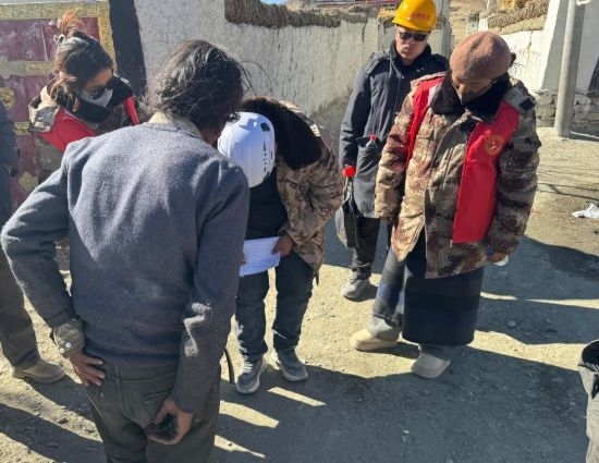 1月13日，次旺（右一）陪同工作組走訪村莊，評(píng)估房屋受損程度。新華社發(fā)