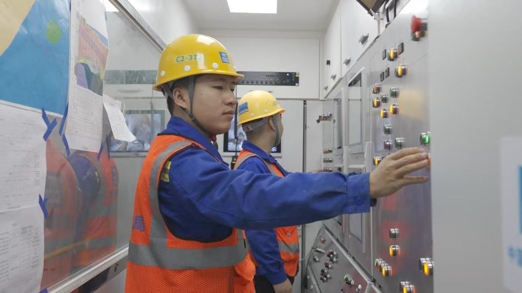 盾構(gòu)司機(jī)何曉波在駕駛室內(nèi)調(diào)試盾構(gòu)機(jī)參數(shù)。（劉芬攝）