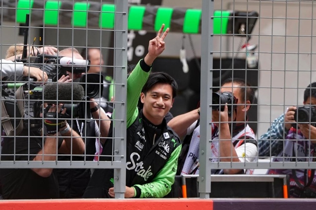 2024年4月19日，索伯車隊(duì)中國(guó)車手周冠宇（中）在練習(xí)賽前向觀眾致意。當(dāng)日，F(xiàn)1中國(guó)大獎(jiǎng)賽在上海開(kāi)賽。中國(guó)車手周冠宇主場(chǎng)首秀參賽。新華社記者 夏一方攝