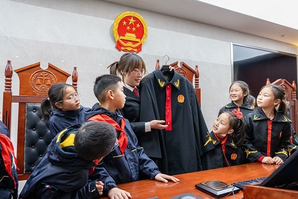 圖②：干警向同學們介紹法袍。