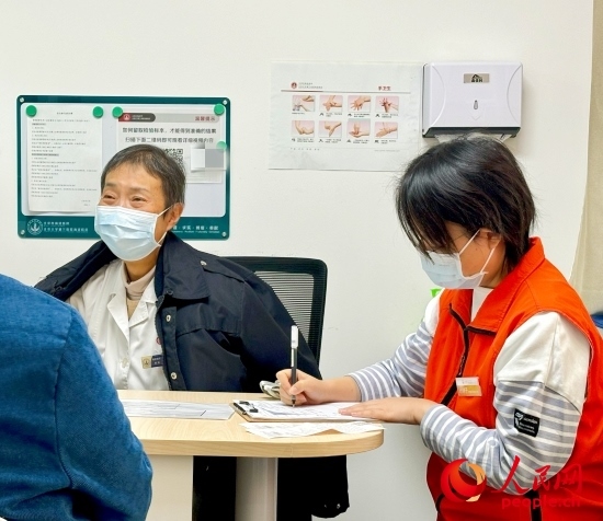 秦苑（中）接診患者。人民網(wǎng)記者 金慧慧攝