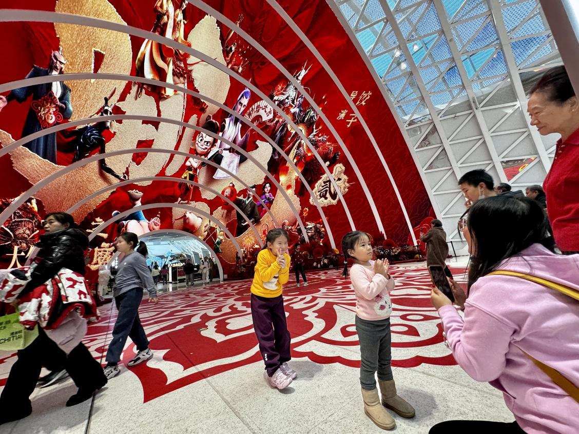 乙巳蛇年春節(jié)期間，影迷在《哪吒之魔童鬧海》巨幅海報(bào)前拍照打卡。