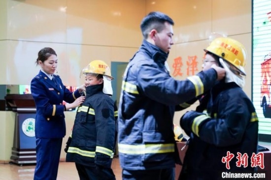圖為學(xué)生們現(xiàn)場(chǎng)穿戴消防頭盔和戰(zhàn)斗服。中新社記者 趙宇航 攝