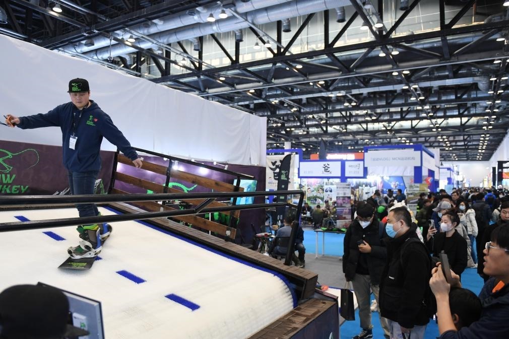 2023年2月11日，參觀者在展會上了解一款模擬滑雪設(shè)備。當日，2023亞洲運動用品與時尚展在國家會議中心拉開帷幕。新華社記者 張晨霖 攝