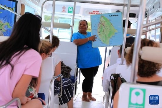 3月15日，一名導(dǎo)游在游艇上為游客介紹塞舌爾拉迪格島。新華社記者 董江輝 攝