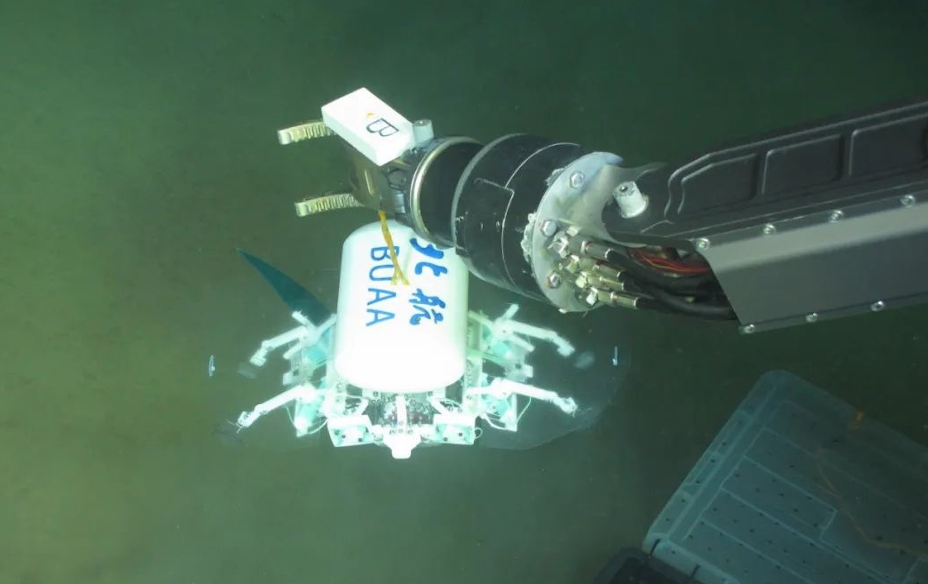 科研人員利用機(jī)械臂將北航深海小型機(jī)器人投于馬里亞納海溝。校方供圖