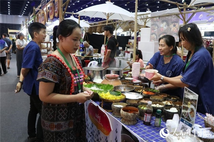 游客在攤位前購買特色美食。朱瀟逸攝