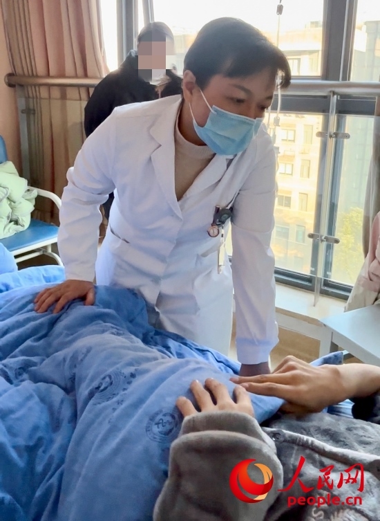 鄧茜查房時(shí)詢問患者情況。人民網(wǎng)記者 金慧慧攝