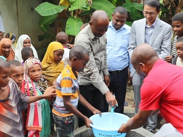 在日前舉行的安全供水工程揭牌儀式上，當(dāng)?shù)匦∨笥言诠┧c(diǎn)接水。 施亮攝