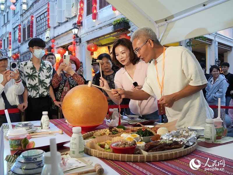 嘉賓品嘗海南傳統(tǒng)美食“煎堆”。人民網(wǎng)記者 張力洋攝