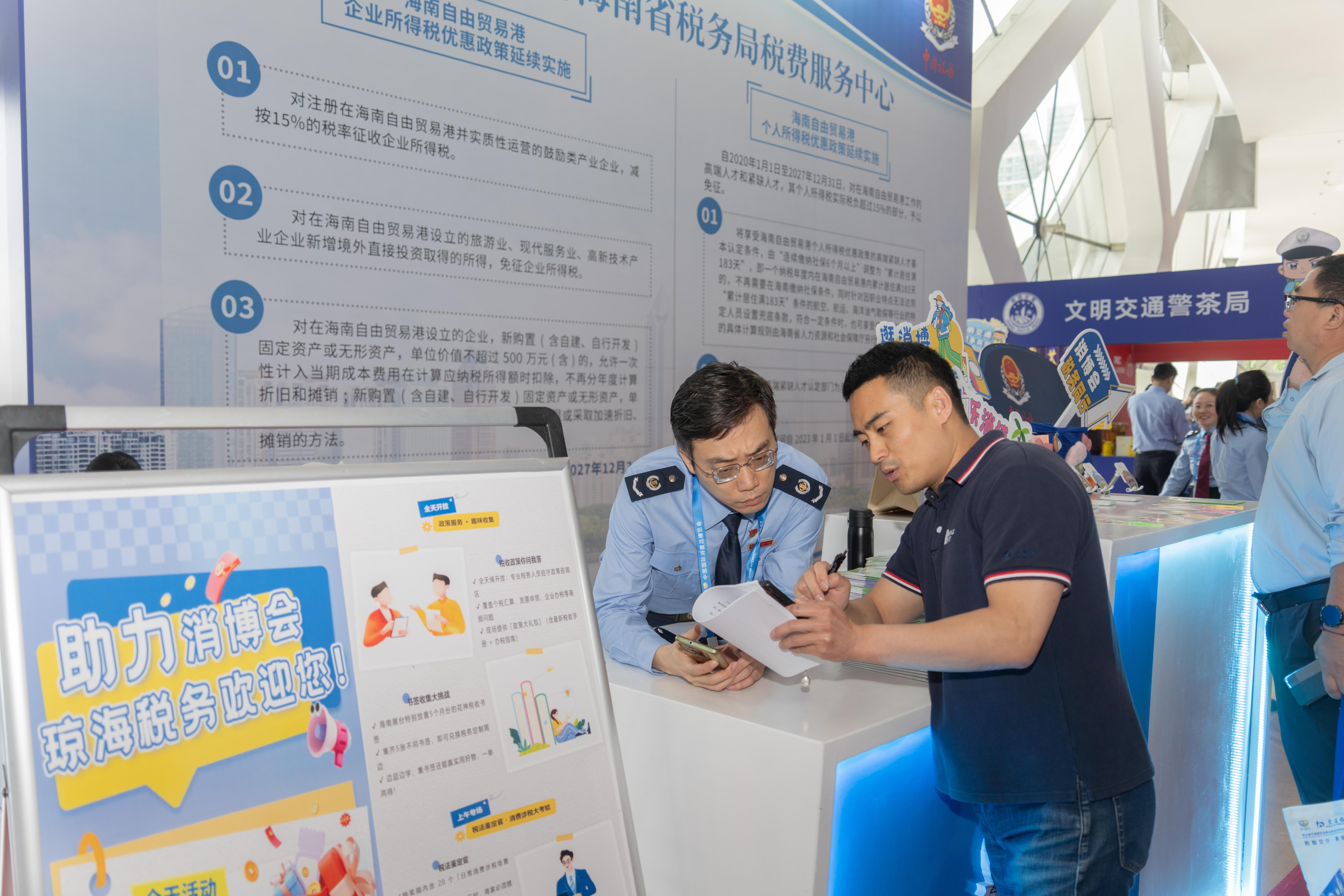 稅務(wù)服務(wù)臺(tái)工作人員向記者介紹服務(wù)參展外商的具體舉措。人民網(wǎng)記者 許崢攝