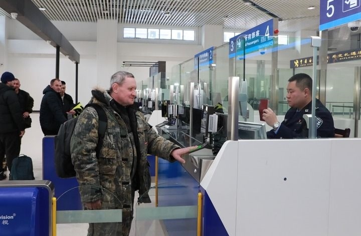 2024年12月10日，在黑河公路口岸旅檢大廳，黑河出入境邊防檢查站民警為首班次客車入境旅客辦理邊檢通關(guān)手續(xù)。當(dāng)日，中國黑河公路口岸—俄羅斯卡尼庫爾干公路口岸旅客運輸正式開通。新華社發(fā)（劉松攝）