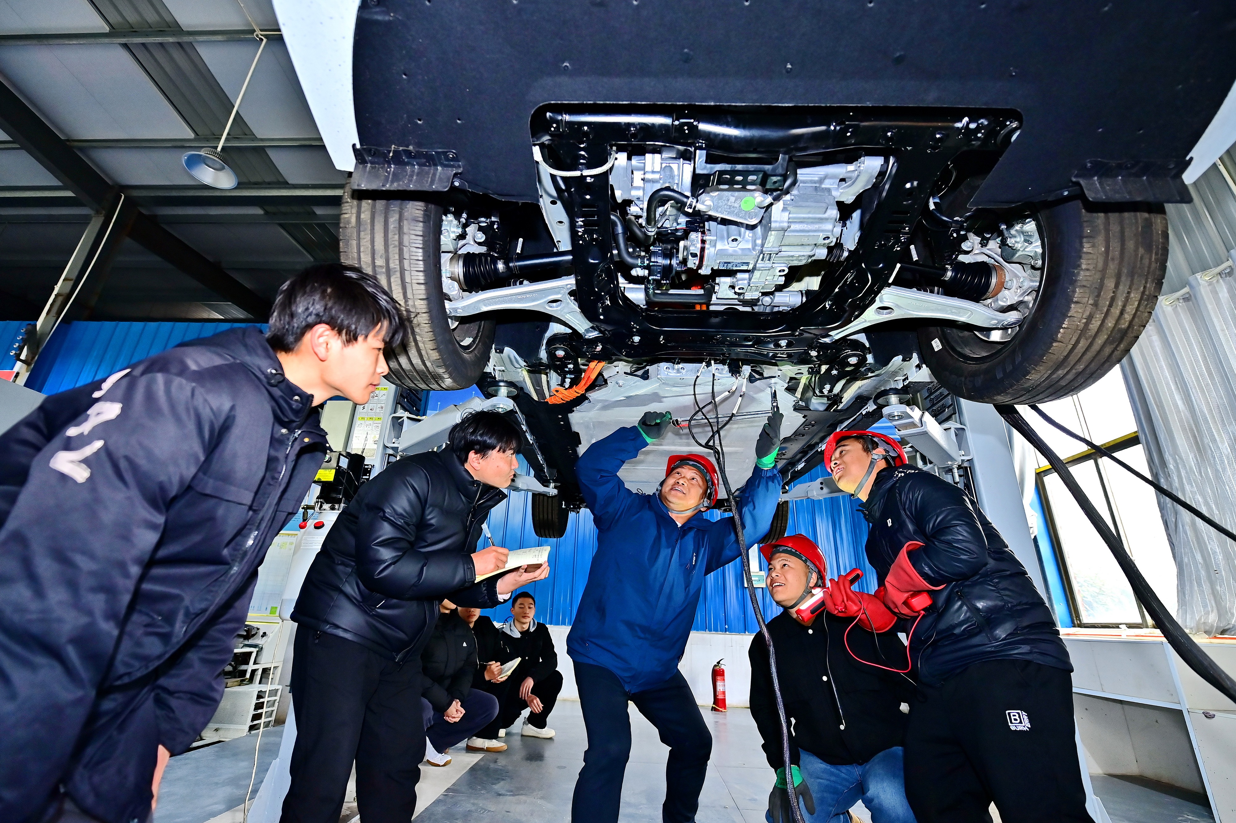 2025年2月，江西省宜春市，豐城市的一所技工學校實訓基地內(nèi)，新能源汽車運維專業(yè)學生在老師的指導下學習新能源汽車電池包檢修技術。