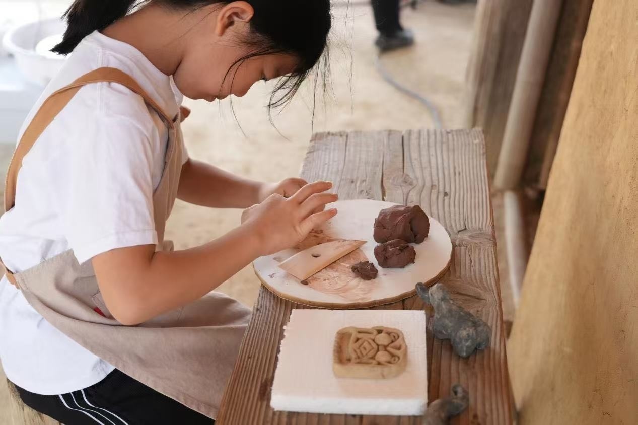游客制作良渚特色陶藝品。良渚博物院供圖