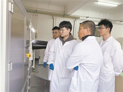 圖為安工大材料科學(xué)與工程學(xué)院碩士研究生余威(右一)在實驗室開展研究。安工大供圖