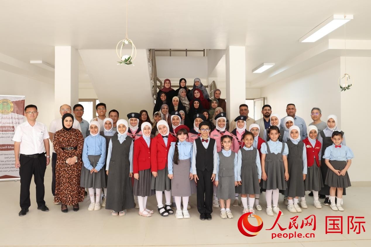 中國電建員工與阿爾穆塔?阿里卡特國際學(xué)校的師生及政府官員等合影。人民網(wǎng)記者 薛丹攝