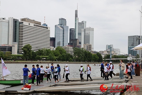 來自美國的快樂龍舟隊(duì)選手們正在登船準(zhǔn)備參賽。人民網(wǎng)記者 劉仲華攝