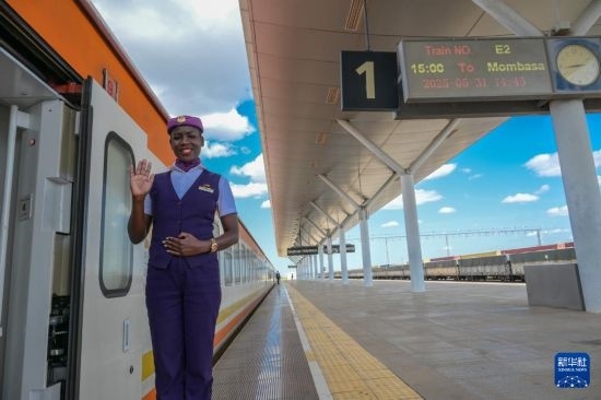5月31日，在蒙內(nèi)鐵路內(nèi)羅畢站，一名乘務(wù)員在即將開往蒙巴薩的E2次列車旁等候乘客。新華社記者 楊光 攝