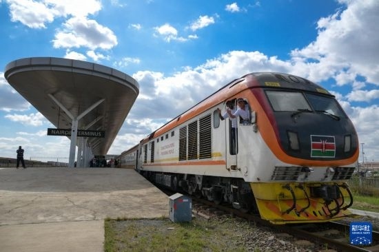 5月31日，在蒙內(nèi)鐵路內(nèi)羅畢站，機車駕駛員蔣立平（右）和博爾在即將開往蒙巴薩的E2次列車上揮手致意。新華社記者 楊光 攝