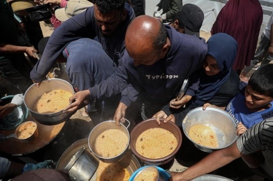 5月28日，人們?cè)诩由吵俏鞑康纳程犭y民營(yíng)領(lǐng)取救助食物。新華社發(fā)（里澤克·阿卜杜勒賈瓦德攝）